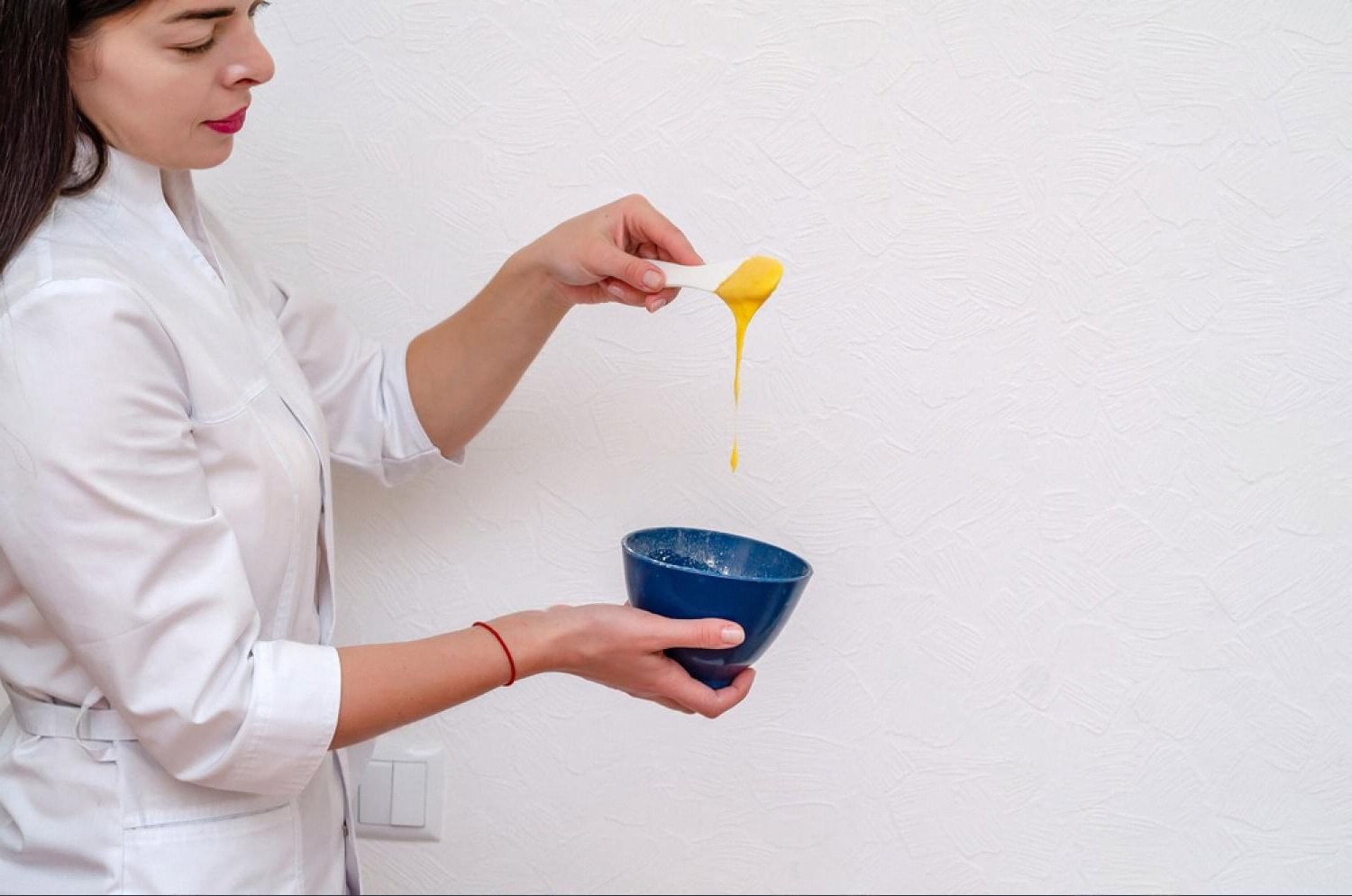 Cosmetologist in a UAE clinic preparing a nourishing face mask