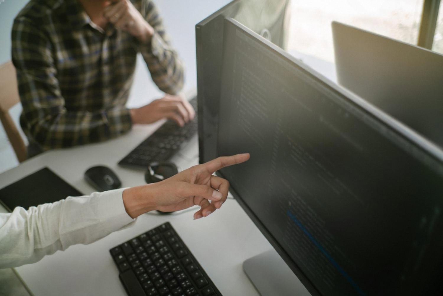 Two people reviewing company data on a computer screen